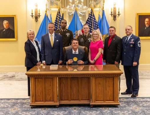 (L-R) Sen. Brenda Stanley, Rep. Josh West, Staff Sgt. Tristan Demartra, Staff Sgt. Brock Wilson, Rep. Nicole Miller, James Hight, and Chief Master Sgt. Scott Irwin join Gov. Kevin Stitt for the ceremonial signing of House Bill 3673. Photo courtesy of the Oklahoma House of Representatives.