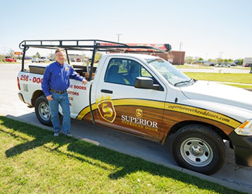 Owner Todd Willhoite stands in front of one of the company’s trucks.  You will see these trucks around the area anytime there is a need for truly superior overhead door installation or service. Value News Magazine & Values, Inc. photo, 2024.