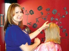 Hair stylist Stephany Hinton applies fun and stylish Featherlocks to a customer’s hair.